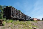 Two livestock cars and other peices of narrow gauge rolling stock sit on display at the Colorado Railroad Museum